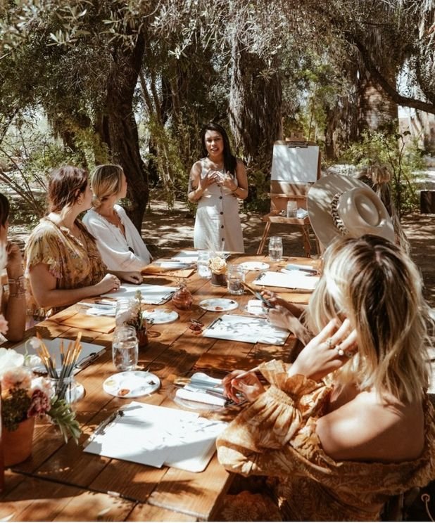 People gathered around a table outdoors at Vila Akoya